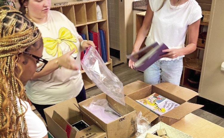 NSU Early Childhood Education and Child and Family Studies majors Aryannah Allen, Rylee Adams, and Emma Grace Wilson gather materials for family literacy bags.