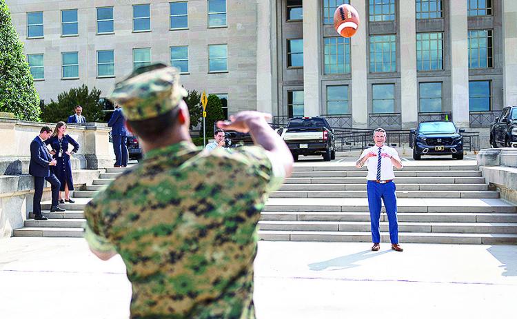 Jacksonville Jaguars NFL player and U.S. Naval Academy graduate Marine Corps 2nd Lt. Rayuan Lane III tosses a football with Defense Secretary Pete Hegseth outside the Pentagon's river entrance during Lane's Pentagon visit, July 2, 2025.