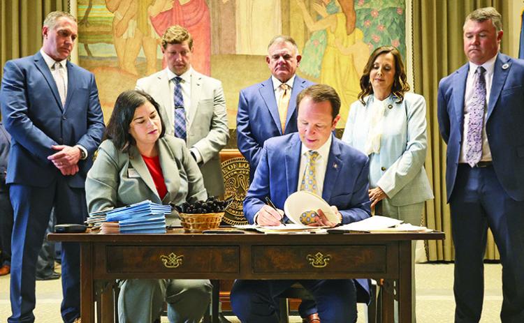 Gov. Jeff Landry signed 11 bills passed by the Legislature as elected officials look on.