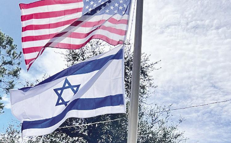Donny and Misty Keeth of Highland Park hoist the national flag of the State of Israel to show their support against Hamas terrorist attacks.
