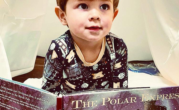 Jack Cotton, 2, looks at his favorite book Christmas night as older brother Levi reads it. His parents are Staci and Jonathon Cotton of Robeline.