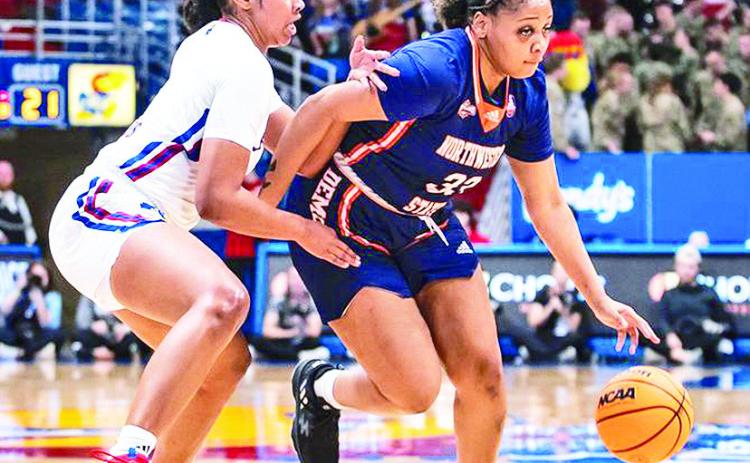 Niaisya Ervin (right) dribbles around defender Ryan Cobbins of Kansas. Photo by Missy Minear, Kansas Athletics
